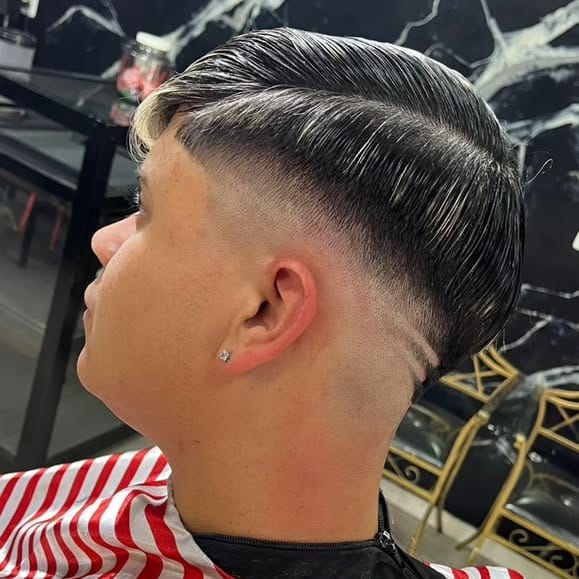 Corte social penteado para trás com degradê baixo e risco, feito na GuiBarbeer